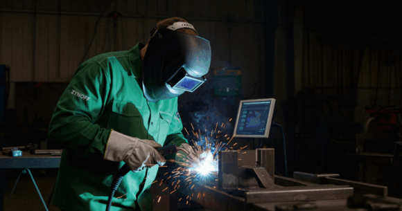 A welder qualified in USA trade school working.